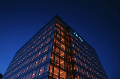 Modern enterprise office building at dusk with warm interior lighting.